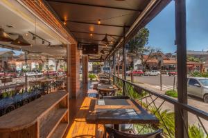 a balcony with tables and chairs and a street at Hotel Laghetto Stilo Centro in Gramado