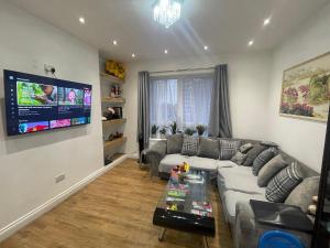 a living room with a couch and a tv at Fresh Apartment & Parking in London