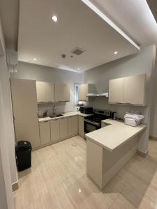 una grande cucina con armadi bianchi e piano di lavoro di Flower 1 Al Mughrizat a Riyad