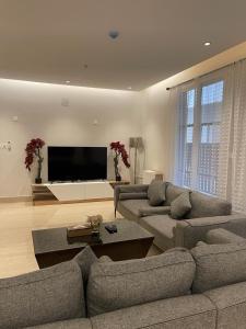 un soggiorno con due divani e una TV a schermo piatto di Flower 1 Al Mughrizat a Riyad