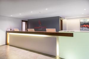 a hotel lobby with a reception desk with chairs at Hotel Laghetto Stilo Centro in Gramado