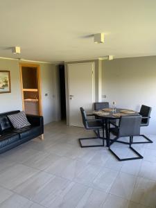 a living room with a table and chairs and a couch at Mengi Apartments Keflavik in Keflavík +5 photos