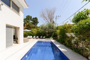 una piscina en el patio trasero de una casa en Maison d architecte en Herzelia 