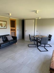 a living room with a black couch and a table at Mengi Apartments Keflavik in Keflavík