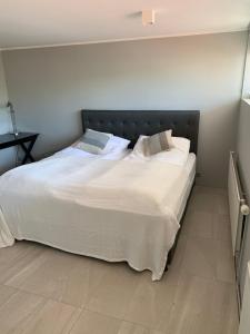 a bedroom with a large bed with white sheets and pillows at Mengi Apartments Keflavik in Keflavík