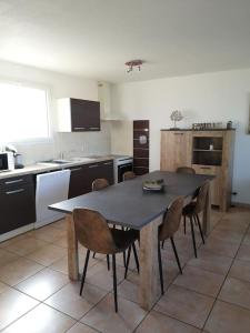 een keuken met een tafel en stoelen. bij Logement entier : Maison in Saleilles