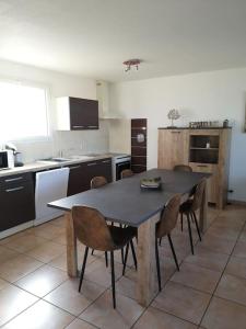 een keuken met een tafel en stoelen erin bij Logement entier : Maison in Saleilles
