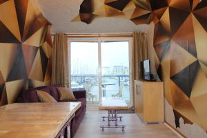 a living room with a couch and a large window at Fantastic Waterside apartment in Brighton Marina in Brighton & Hove