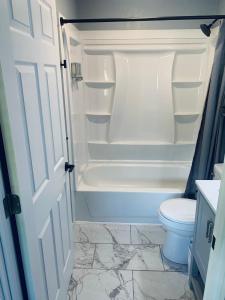 a bathroom with a toilet and a tub and a sink at TeePee Room 6- Newly Renovated in Roscommon