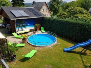 un patio trasero con piscina y tobogán en Ferienwohnung an der Kurpromrnade, en Bad Schandau