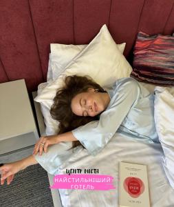 une femme qui se couche sur un lit avec la tête sur un oreiller dans l'établissement Deribas Hotel, à Odessa