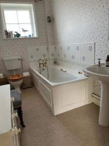 uma casa de banho com uma banheira branca e um lavatório. em Highfield Farm em Fakenham