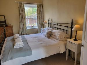 a bedroom with a large white bed with a window at Highfield Farm in Fakenham