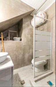 La salle de bains est pourvue de toilettes blanches et d'un lavabo. dans l'établissement Stunning studio near center of athens, à Athènes