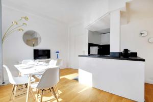 cocina blanca y comedor con mesa y sillas en Superb 2BR apartment - Suresnes en Suresnes