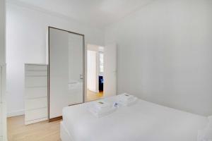 Dormitorio blanco con espejo y cama en Superb 2BR apartment - Suresnes en Suresnes