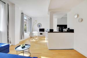 a white apartment with a kitchen and a living room at Superb 2BR apartment - Suresnes in Suresnes