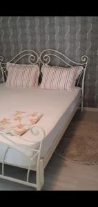 a white bed with two pillows on it at Guest rooms KRASI 