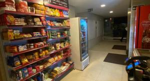 a grocery store aisle with a refrigerator and shelves of food at Flat Eco Summer Tambaú Apto 2Qts, Cozinha completa in João Pessoa