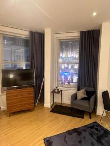 a living room with a flat screen tv and a window at Tranquil 1 BR Retreat in Piccadilly VR4 in London