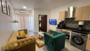 sala de estar con sofá y sillas en una habitación en Accra Luxury apartments at Oasis Park Residences, en Accra
