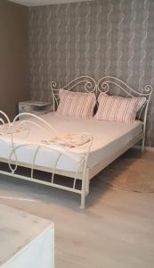 a white bed with two pillows on it at Guest rooms KRASI 