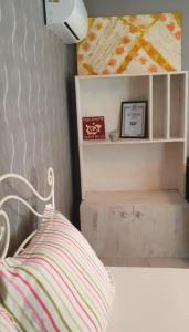 ein Schlafzimmer mit einem Bett mit gestreiftem Kissen und einem Regal in der Unterkunft Guest rooms KRASI 