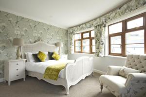 a bedroom with a white bed and a chair at Exmoor White Horse Inn in Exford