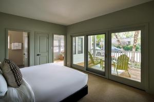 ein Schlafzimmer mit einem Bett und einem Balkon in der Unterkunft The Neighborhood Hotel New Buffalo in New Buffalo