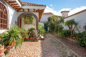a courtyard of a house with potted plants at Hotel Beth Sarim By Legendary in Villa de Leyva