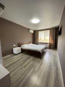 Mini Hotel في Liski: غرفة نوم بسرير ونافذة كبيرة