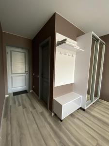 um quarto vazio com um frigorífico branco e uma porta em Mini Hotel em Liski