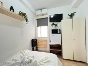 een slaapkamer met een bed en een witte koelkast bij Estudio Augusto Acogedor 2 in Madrid