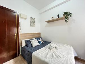 een slaapkamer met een bed en een plank aan de muur bij Estudio Augusto Acogedor 2 in Madrid