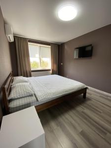um pequeno quarto com uma cama e uma televisão em Mini Hotel em Liski