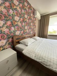 sypialnia z łóżkiem i tapetą w kwiaty w obiekcie Mini Hotel w mieście Liski