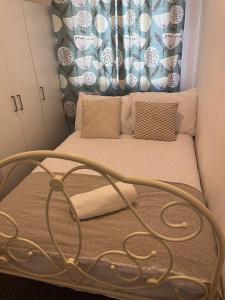 a small bed in a room with a curtain at Inviting Town House in Coventry