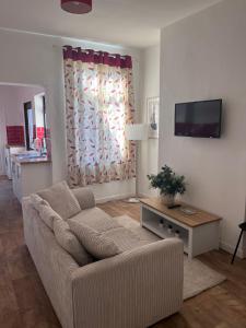 a living room with a couch and a flat screen tv at Inviting Town House in Coventry
