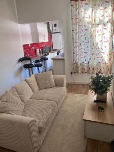 a living room with a couch and a kitchen at Inviting Town House in Coventry