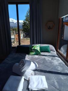 a bedroom with a bed with towels and a window at Tiny house Bariloche in San Carlos de Bariloche
