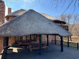 una capanna con panchina e tetto in erba di Schoemanshof a Potchefstroom