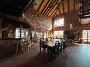 una grande camera con tavolo e sedie in legno di Schoemanshof a Potchefstroom