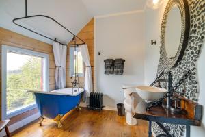 a bathroom with a blue tub and a sink at Luxe 14-Acre Vermont Countryside Vacation Rental! in East Orange