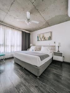 una camera con un grande letto e un ventilatore a soffitto di Hotel Puerto Chinchorro ad Arica