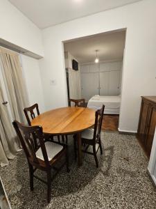 een tafel en stoelen in een kamer met een slaapkamer bij En el Centro in Salta