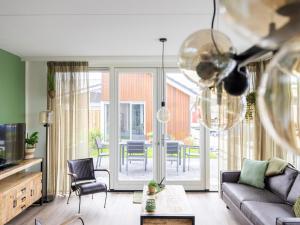 uma sala de estar com um sofá e uma mesa em Lakehouse I em Uitgeest