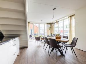uma cozinha e sala de jantar com mesa e cadeiras em Lakehouse I em Uitgeest