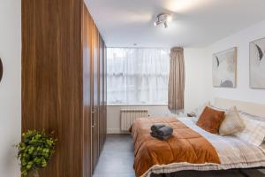 a bedroom with a bed and a large window at Modern flat in central golders green in London