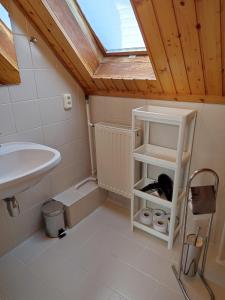 une petite salle de bains avec un lavabo et une lucarne. dans l'établissement Aranyharmat Apartman, à Balatonlelle