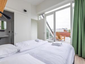 um quarto com 2 camas e uma grande janela em Lakehouse I em Uitgeest
